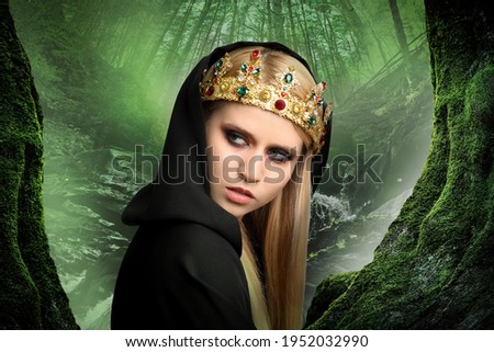 Witch wearing black mantle and crown in misty forest. Scary fantasy character