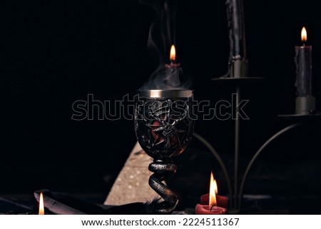 Witchcraft composition with candles, magic book and pentagram symbol. Altar for satanic rituals. Black magic and occult objects.