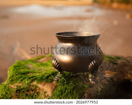 Witches cauldron burning a spell beside the sea 