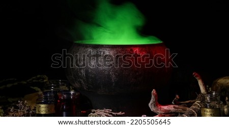 Witch's cauldron with potion and magic attributes for ritual on dark background