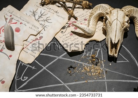 Witch's magic attributes with drawn pentagram on dark background