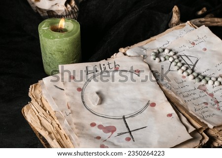 Witch's magic attributes with spell book on dark table, closeup