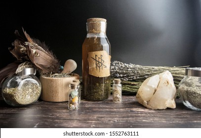 Witch's Potion In A Bottle With Runes, Dry Herbs And Test Tubes On A Wooden Background, Magic And Witchcraft, Wicca