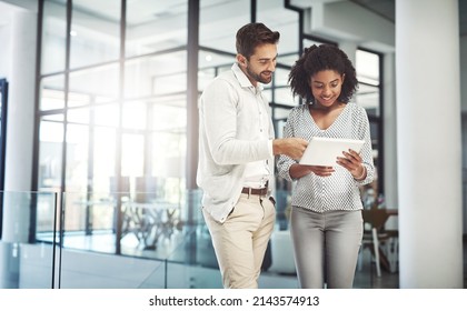 Without Communication, Collaboration Is Impossible. Shot Of Two Businesspeople Discussing Something On A Digital Tablet.