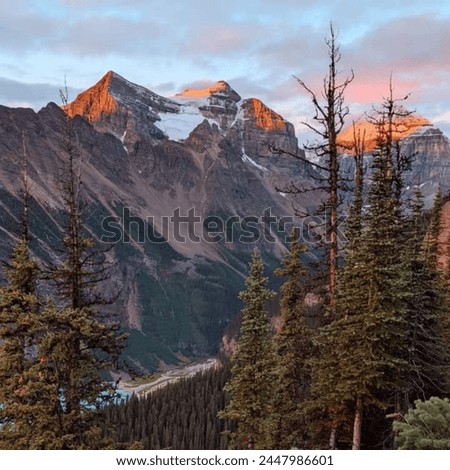 Witness the awe-inspiring beauty of a sunrise over the majestic mountains in Banff National Park. 