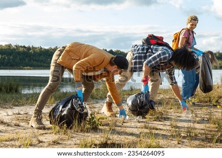 Witness the inspiring unity of a diverse group of young volunteers as they come together to make a positive impact on the environment. This image captures their collective effort in cleaning up the