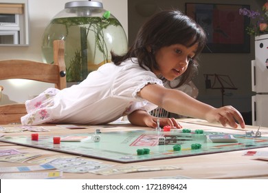 Witney, Oxfordshire, UK 08 05 2009 A Girl Moves Her Piece Around A Monopoly Board