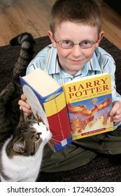 Witney, Oxfordshire, UK 11 12 2007 A Boy In Glasses Reading Harry Potter And The Order Of The Phoenix With His Cat