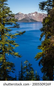 Wizard Island Is A Volcano Within A Volcano In Crater Lake Oregon, Scene Here Thru The Trees From The Rim Drive