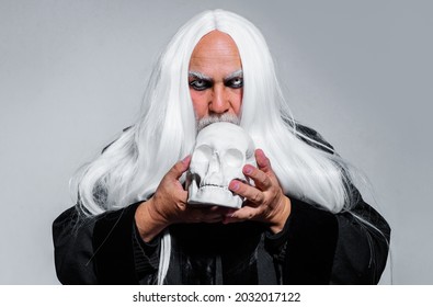 Wizard With Skull. Vampire Man With White Eyes. Bearded Old Man Dressed In Sorcerer Costume For Halloween. Horror, Scary, Spooky.