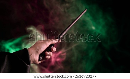 Wizard's hand casting magic with a wand, surrounded by mystical green and purple smoke. Harry potter day,magic.