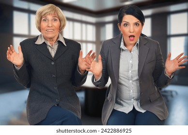 wo women express surprise and astonishment in the office, reacting to unexpected news or a surprising development in their workplace - Powered by Shutterstock