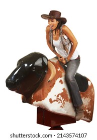 Woah. Studio shot of a beautiful young woman riding a mechanical bull against a white background.
