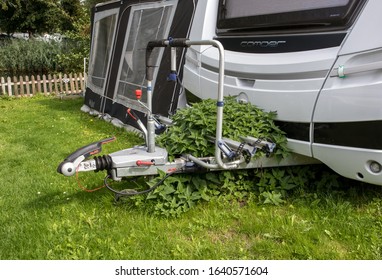 Woerden / Netherlands - September 18, 2019 : Front of touring caravan showing hitch which is overgrown with plants and awning - Shutterstock ID 1640571604