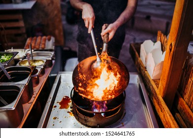 Wok cooking a traditional stir fry. Street food in China, South-East Asia