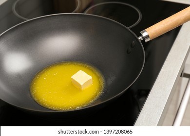 Wok Pan With Melted Butter On Stove