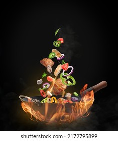 Wok With Tasty Ingredients And Fire On Black Background