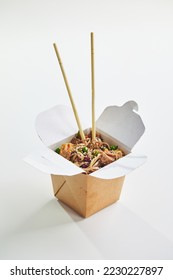 Wok with turkey meat, Soba noodles, paprika, mushrooms and carrot in take-out box with chopsticks. Asian food delivery, concept of street food