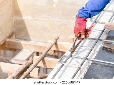 Woker Holding Pliers Bundle Wire Steel Rebar In Construction Site.