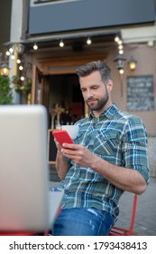 Woking Remotely. Bearded Handsome Chacking Hos Phone In Open Air Cafe