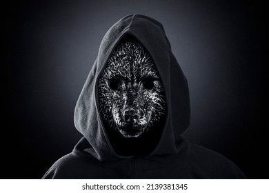 Wolf in hooded cloak at night over dark misty background - Shutterstock ID 2139381345