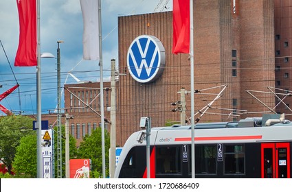 Wolfsburg, Germany, April 30., 2020: View over a local train to the power plant of the Volkswagen car factory with the big VW logo