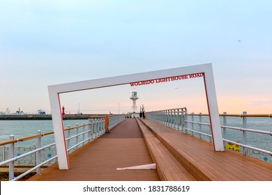 Wolmido Island, Jung-gu, Incheon, South Korea - March 1, 2020: Slightly Slanted Frame On Wood Deck Against A Lighthouse And Incheon Bridge In The Background
