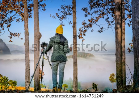woma traveller or photographer in motion of enjoy the nature moning of the mist and foggy flowing in between the hills mountain