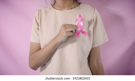 womaen hand holding pink ribbon breast cancer awareness. concept healthcare and medicine. cancer concept - Shutterstock ID 1921802453
