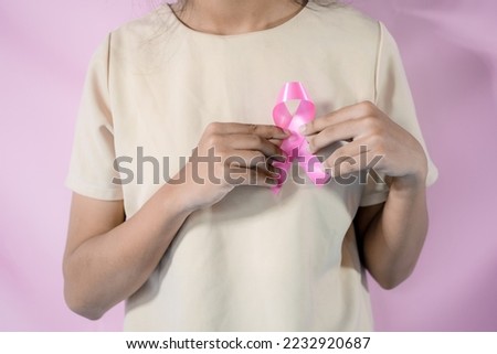womaen hand holding pink ribbon breast cancer awareness. concept healthcare and medicine. cancer concept