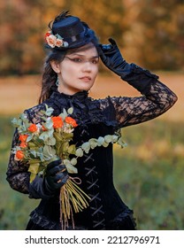 Woman In An 18th-19th Century Dress With A Bouquet Of Roses In Autumn