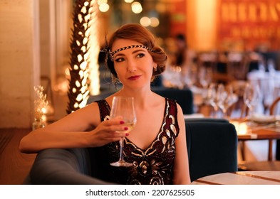 Woman in 1920 style clothes with a glass of wine. Beautiful girl retro flapper style retro vintage roaring 20s.  - Powered by Shutterstock