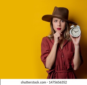 Woman in 1940s style clothes with alarm clock