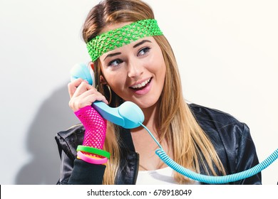 Woman In 1980's Fashion With Old Fashioned Phone On A White Background