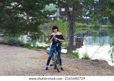 Woman 40-44 years old on a bicycle. The girl decided to get in shape for the beginning of summer.
