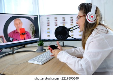 woman 40-45 years old, pretty female blogger sits in front of computer with green screen in front of microphone, emotionally talks on topic of business, communication during quarantine covid 19