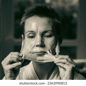 woman 43 years old with a cosmetic mask on her face - Shutterstock ID 2363990813