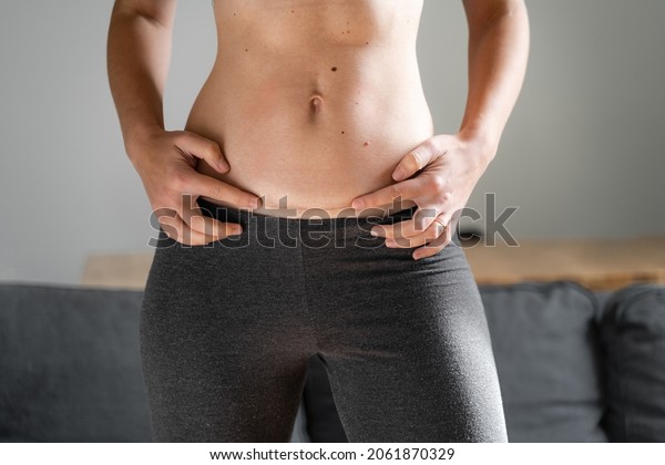 Woman abdomen with cesarean scar. Home candid lifestyle.\
C section surgery for pregnant woman. Recovering after birth.\
