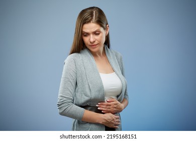 Woman With Abdominal Pain With Hands On Her Stomach Looking Down. Isolated Female Portrait On Blue.