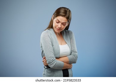 Woman With Abdominal Pain With Hands On Her Stomach Looking Down. Isolated Female Portrait On Blue.