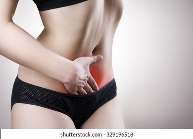 Woman with abdominal pain. Pain in the human body on a gray background with red dot