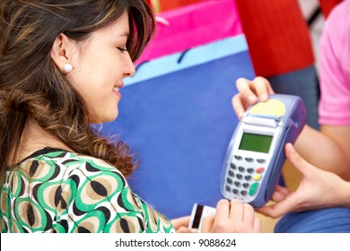 Woman About To Enter The Pin Number After Paying By Credit Card At A Clothes Store