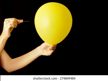 Woman About To Pierce A Balloon With A Needle