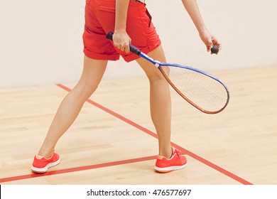 Woman about to serve the ball in the squash court