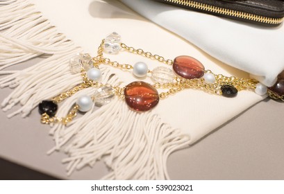 Woman Accessories A Wallet And A Necklace On A White Scarf