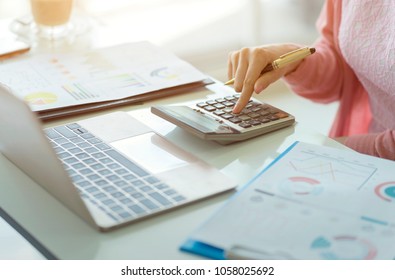 Woman Accountant Working On Accounts In Business Analysis With Graphs And Document Financial Data Report With Laptop Computer, Planning Tax Payment At Office, Business Concept.