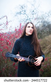 Woman With An Acoustic Guitar In The Wood