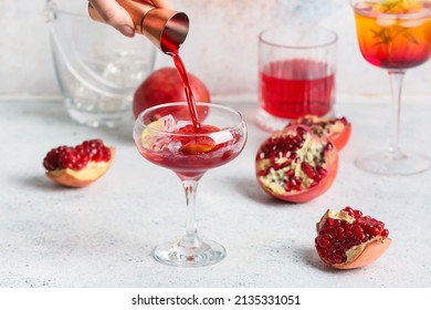 Woman Adding Pomegranate Syrup In Glass On Light Background