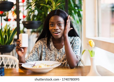 Woman Adding Salt To Food In Restaurant.