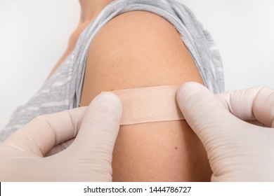 Woman with adhesive bandage on her shoulder - injury concept